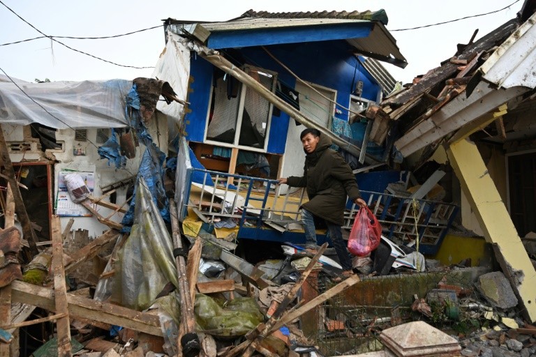 Un bărbat recuperează bunuri dintr-o casă distrusă după un cutremur cu magnitudinea 5,6 care a ucis cel puțin 162 de persoane și a lăsat sute de răniți și dispăruți în Cianjur, pe 22 noiembrie 2022.