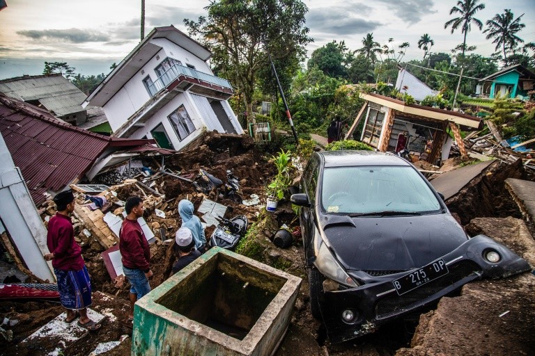 Des habitants récupèrent leurs affaires dans leurs maisons endommagées, suite à un séisme de magnitude 5,6 qui a fait au moins 162 morts, des centaines de blessés et des disparus à Cianjur, le 22 novembre 2022